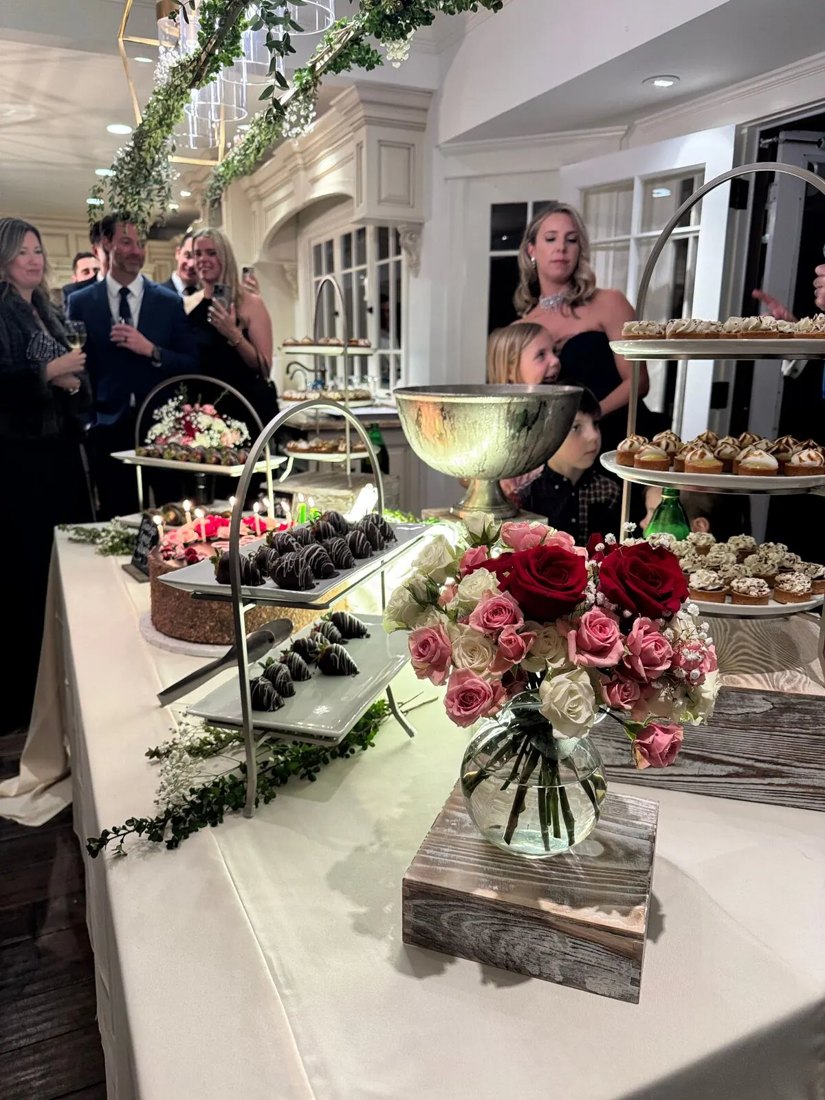 Wedding sweets table of dipped strawberries and petite pastries surrounded by fresh garden roses — wedding dessert florals for Capitola catering receptions