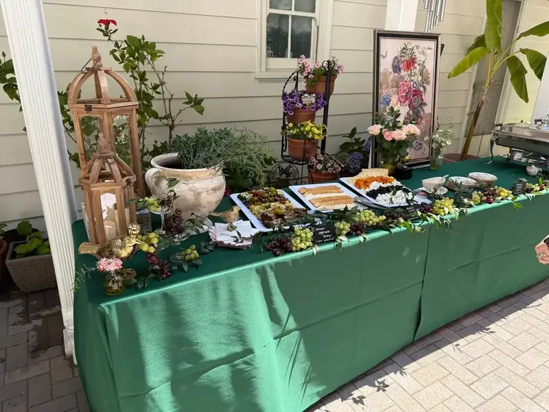 Outdoor private party spread of grazing platters, seasonal blooms, greenery, and lanterns on a long table — Soquel and Live Oak catering for backyard celebrations